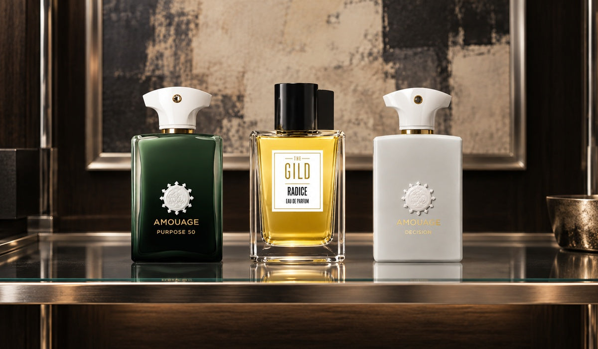 Amouage Purpose 50, THE GILD Radice and Amouage Decision on a luxury smoked-glass shelf with a blurred cream and charcoal painting.