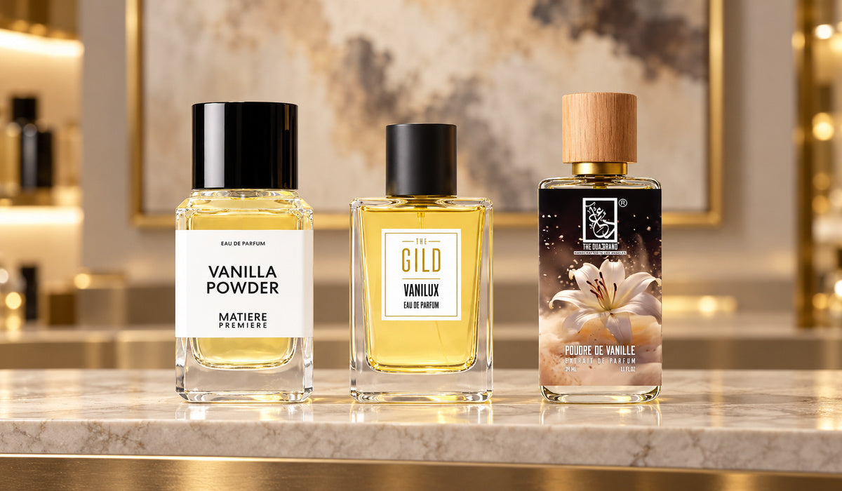 Matière Première Vanilla Powder Eau de Parfum, THE GILD Vanilux and DUA Poudre De Vanille on a pale stone retail shelf with softly blurred cream artwork.