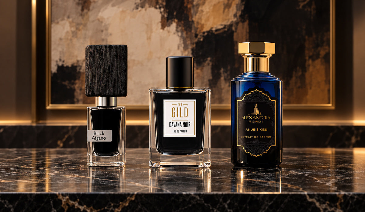 Nasomatto Black Afgano, THE GILD Davana Noir and Alexandria Anubis Kiss on a dark marble shelf with blurred brown and cream artwork.