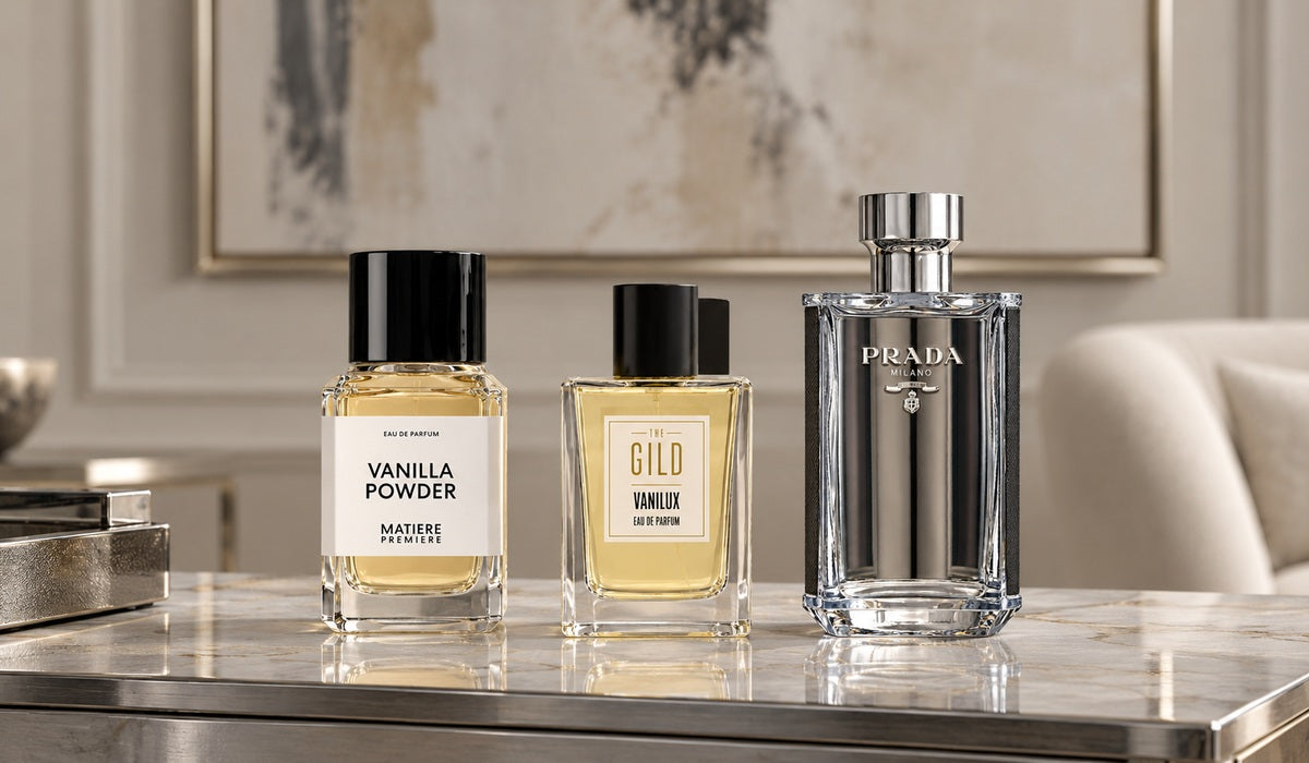 Matière Première Vanilla Powder, THE GILD Vanilux and Prada L’Homme on a silver and pale stone dresser.