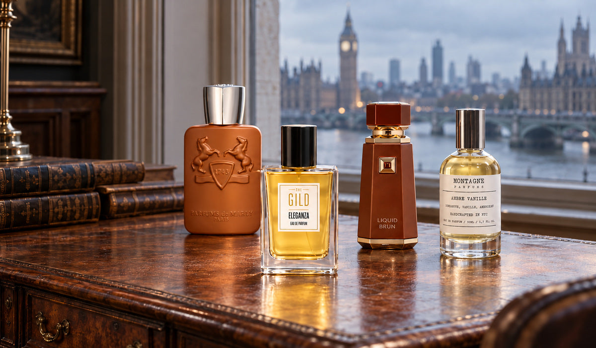 Eleganza, Althaïr, Liquid Brun and Ambre Vanille on a vintage walnut desk with a cold, blurred London cityscape beyond the window.
